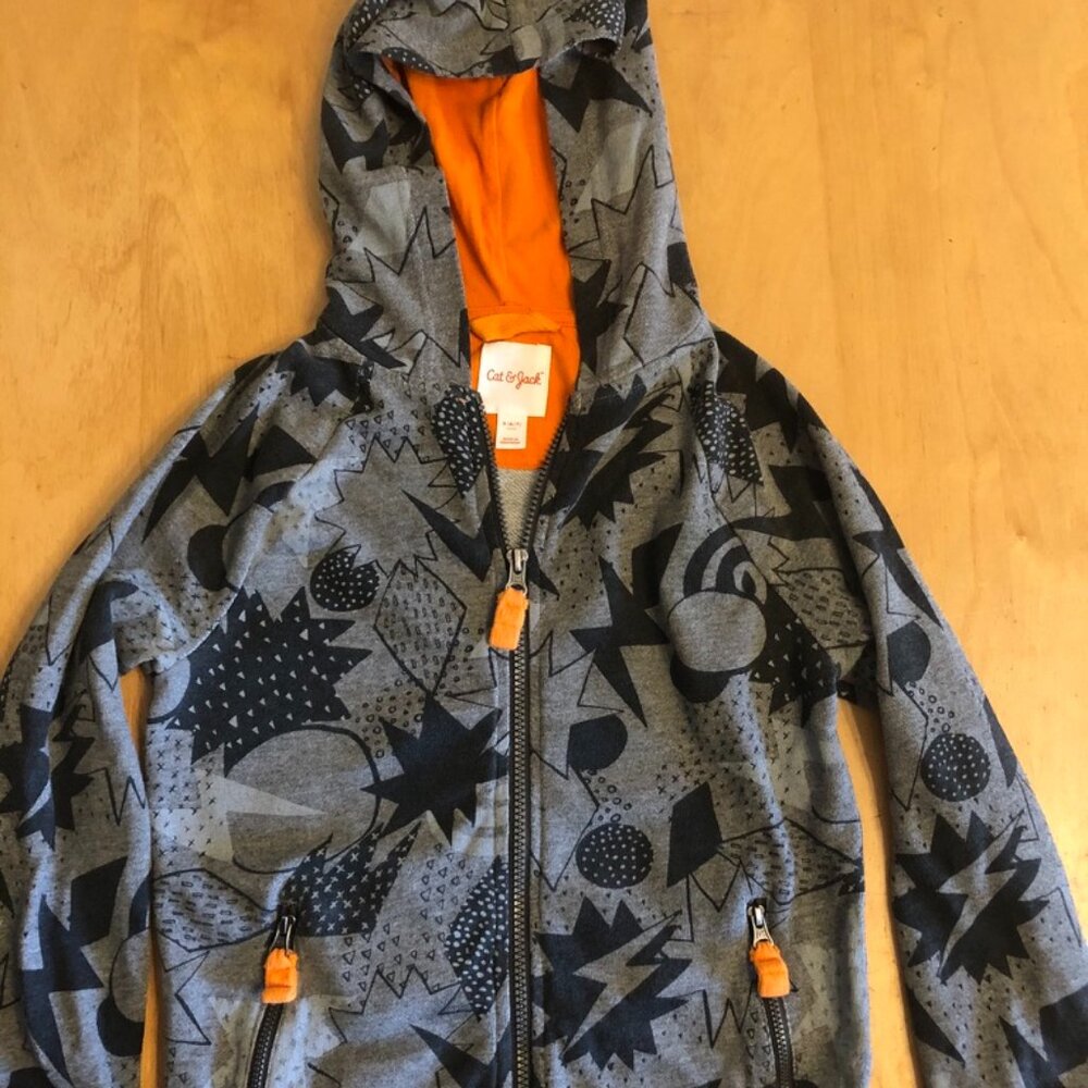 Grey sweatshirt with abstract black pattern and orange detailing